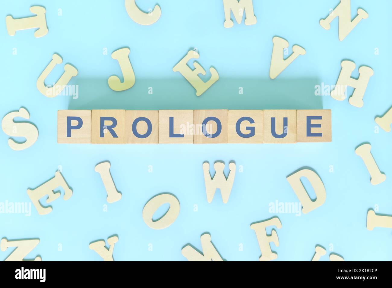 Prologue part of a book concept. Wooden blocks typography word flat lay in blue background Stock Photo
