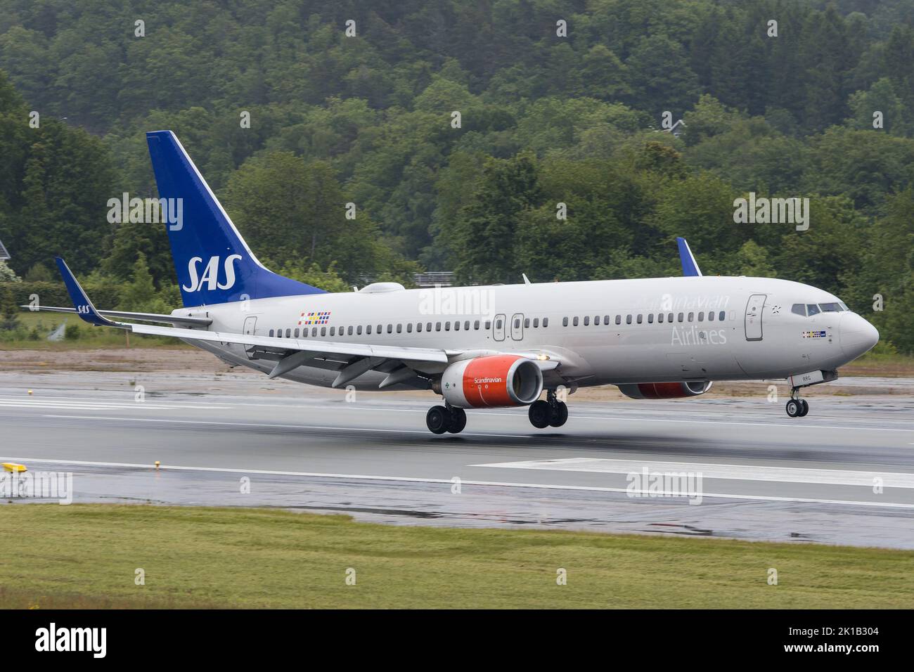 A Boeing 737-800 jet airliner of SAS Scandinavian Airlines landing on a wet runway in Kristiansand in Norway Stock Photo