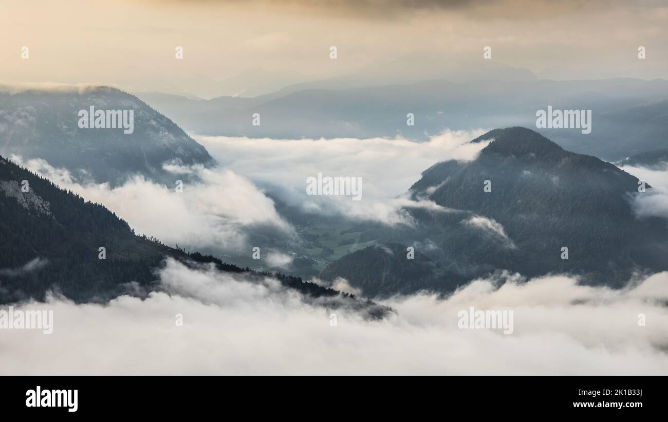 Cloudy weather condition with fog, clouds and a bit of sun in the Salzkammergut mountains in Austria Stock Photo