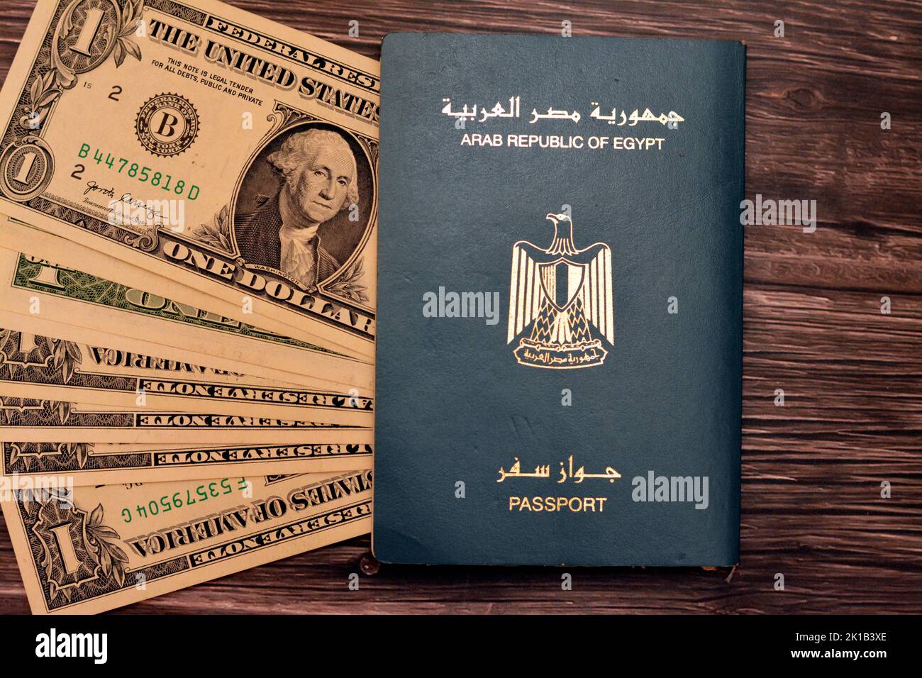 Egyptian passport with American dollars of 1 $ one United states money banknotes isolated on wooden background, Arab republic of Egypt's passport with Stock Photo