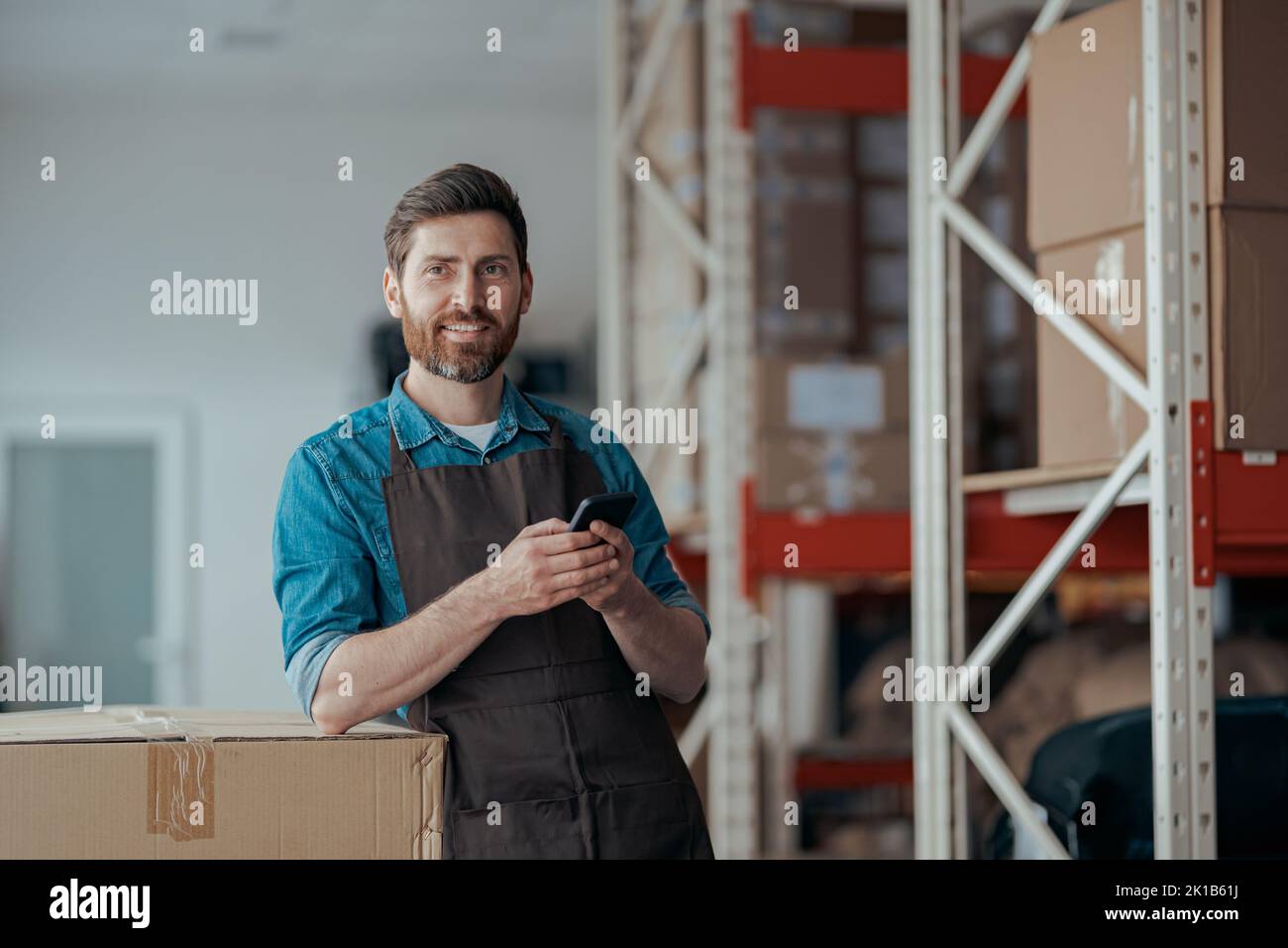 Portrait of male worker in uniform standing on warehouse of manufacturing  Stock Photo