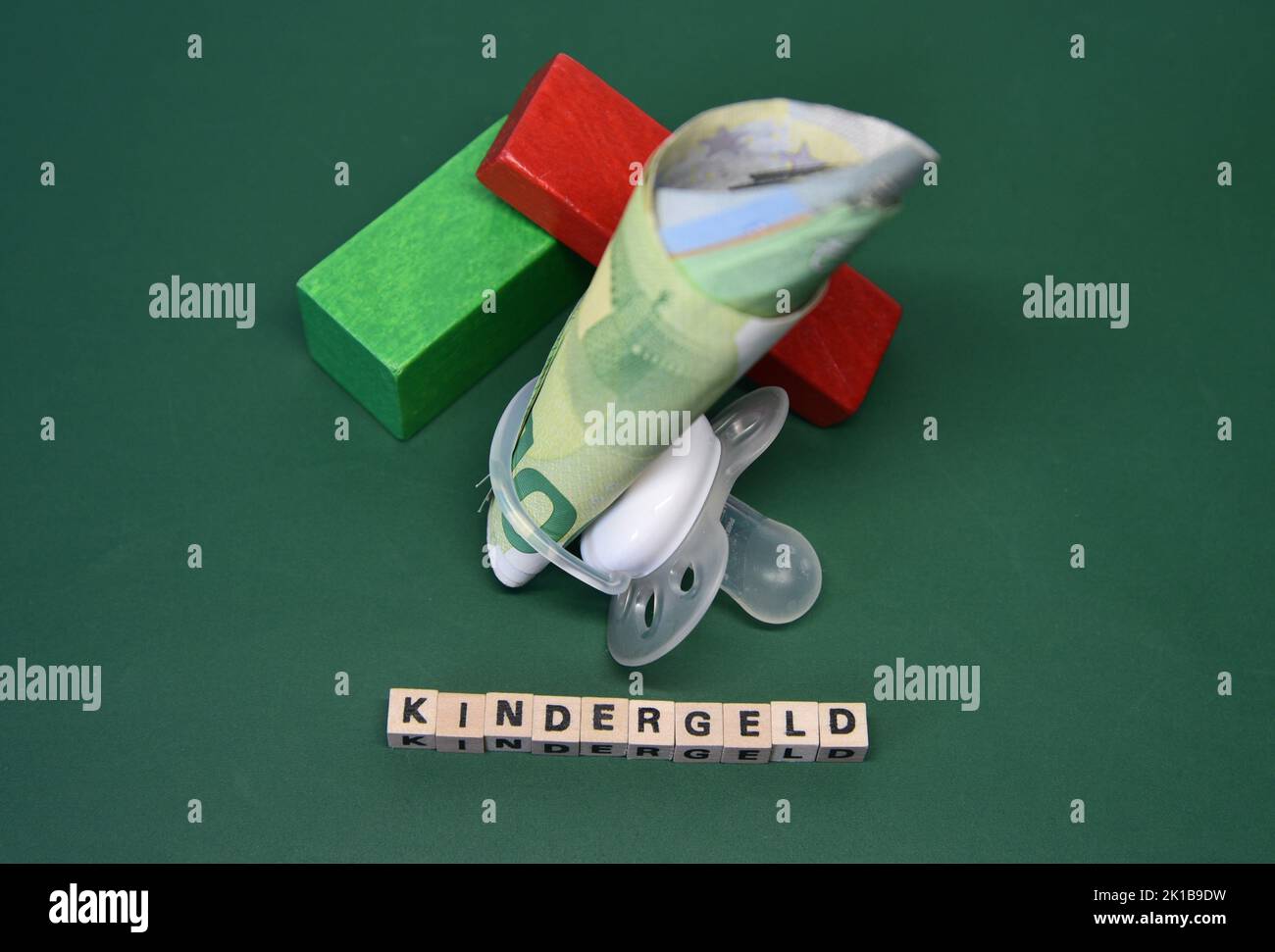 the word child benefit with wodden bricks, a pacifier and euro bank notes Stock Photo
