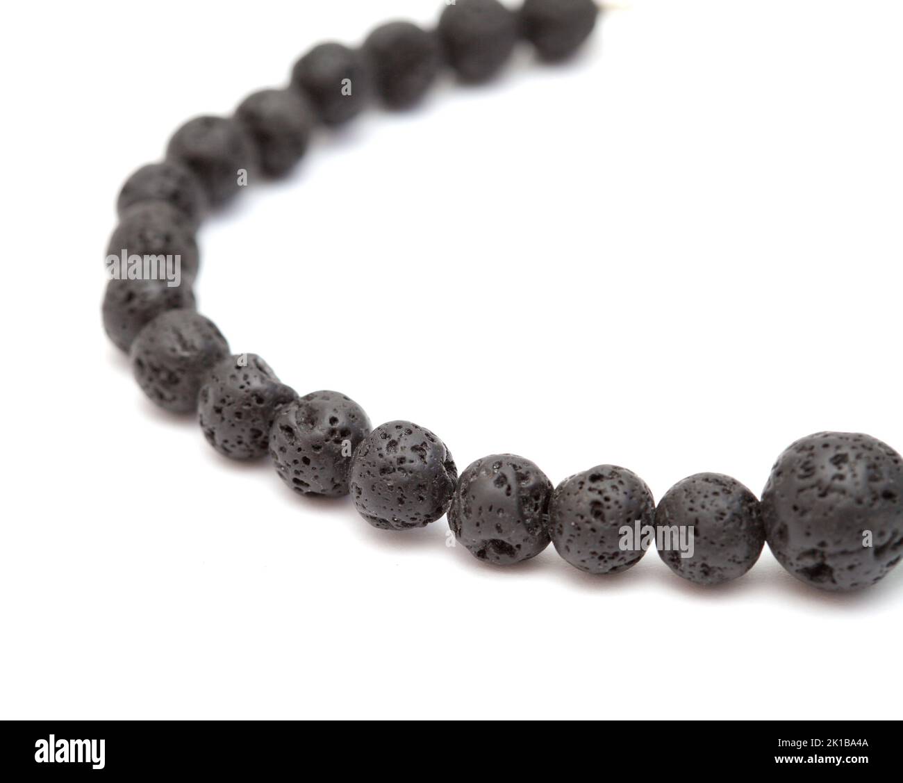Holiday jewelry - simple necklace made of black porous volcanic beads isolated on white background Stock Photo