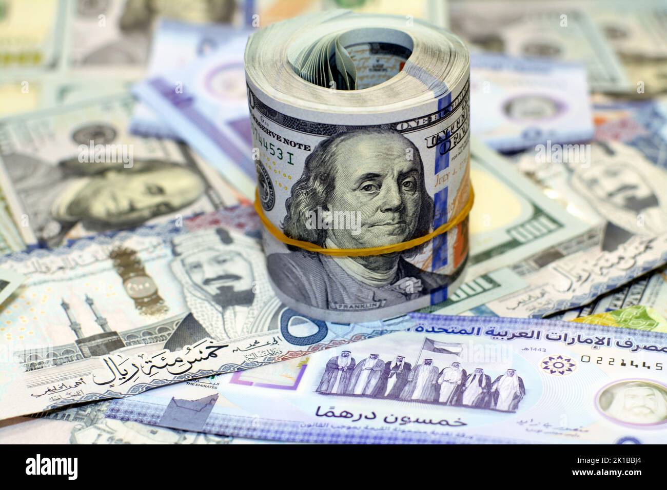 American money roll with a band on a pile of American dollar bills ...