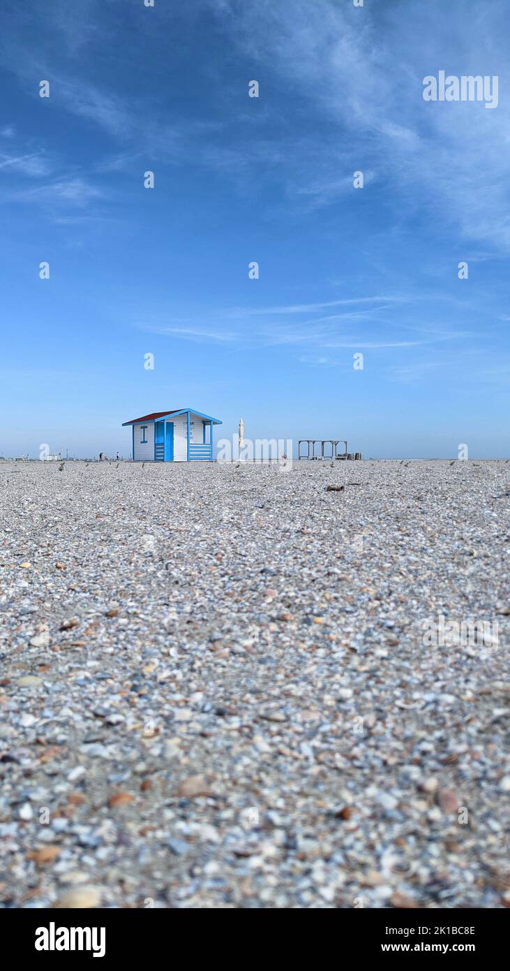 Empty beach with a single blue sea house under clear blue sky Stock Photo