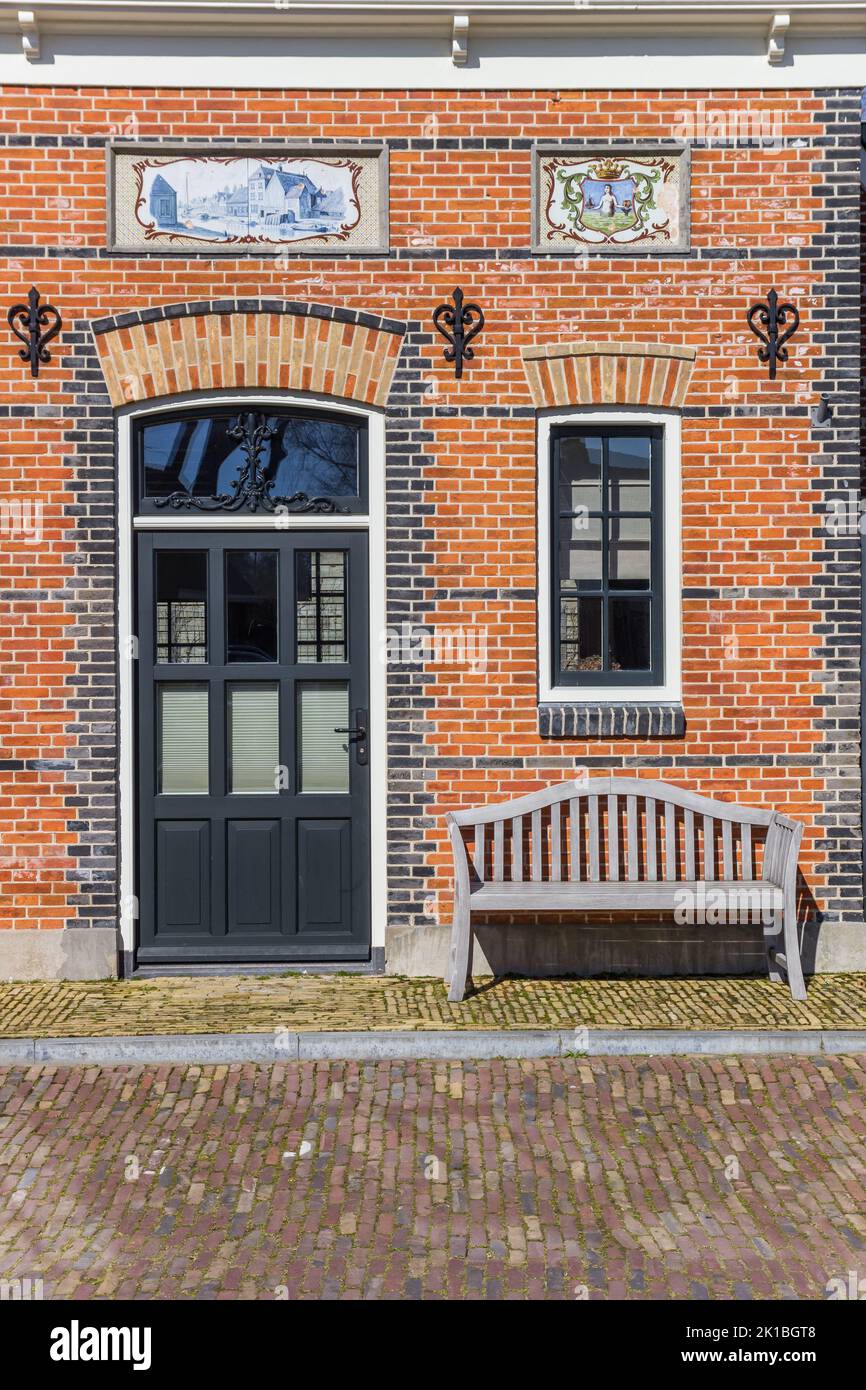 Wooden bench in front of a traditional dutch house in Makkum, Netherlands Stock Photo
