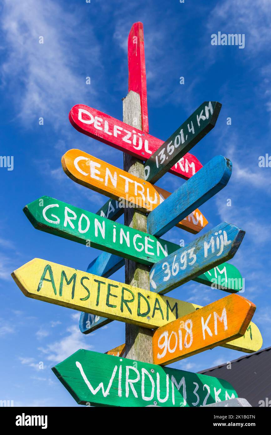 Colorful signpost pointing to various cities in Appingedam, Netherlands Stock Photo