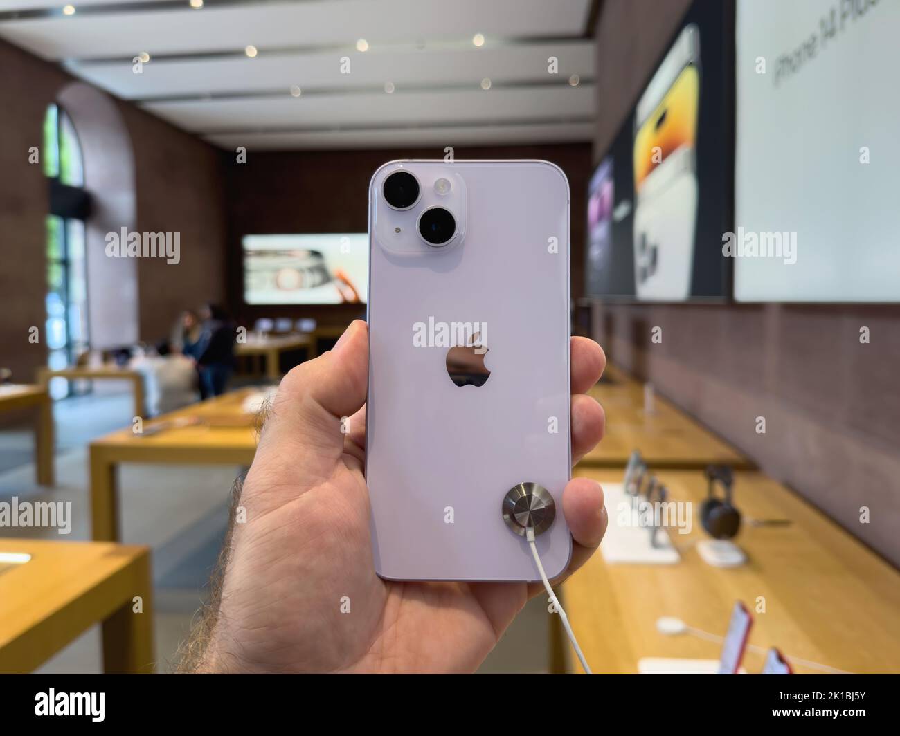 Paris, France - Sep 16, 2022: Customer holding new purple colored Apple Computers iPhone 14 during the launch day featuring new dual powerful camera car crash detection; and satellite SOS Stock Photo