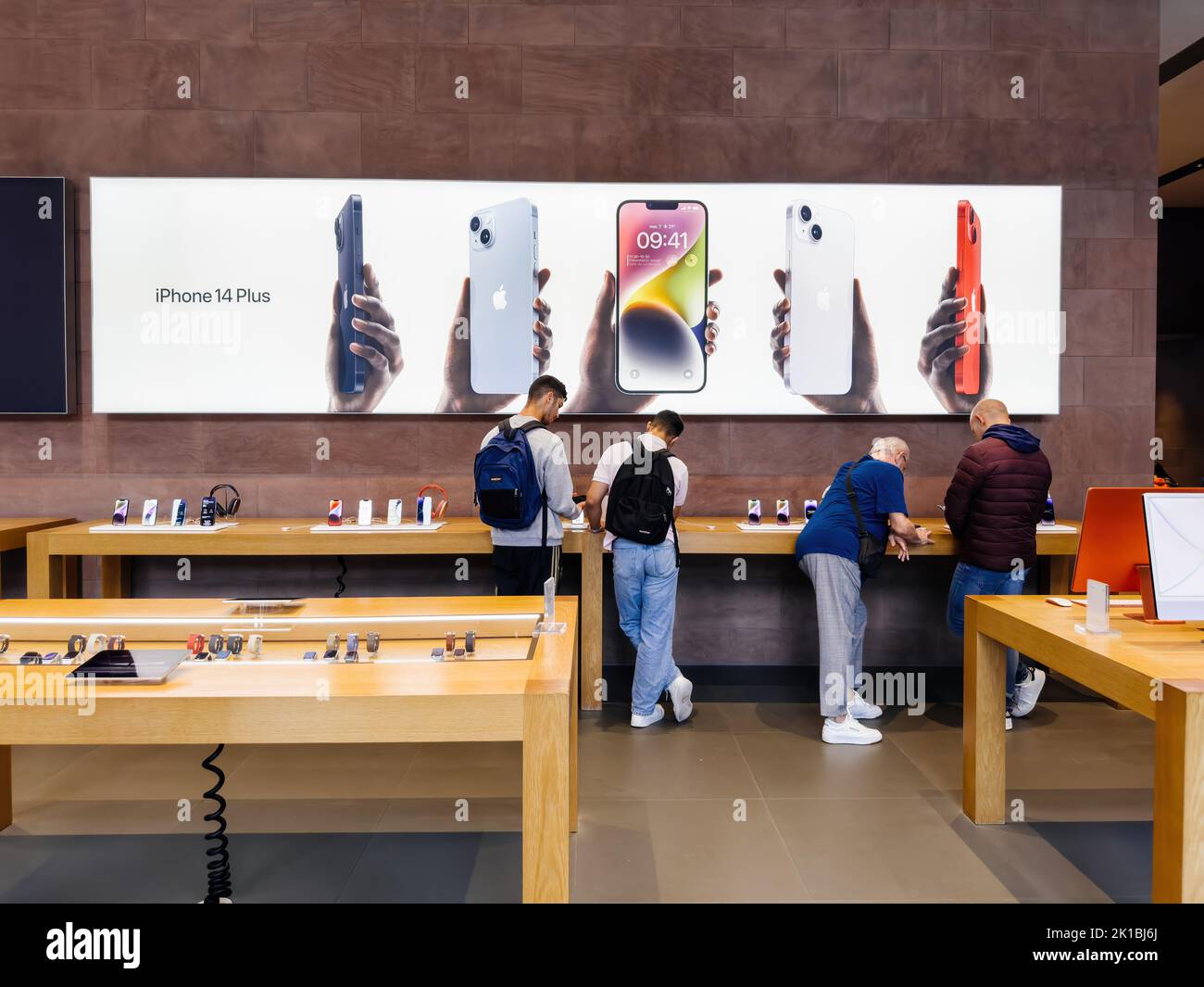 Paris, France - Sep 16, 2022: Customers people under large advertising of the new Apple Computers iPhone 14, 14 Pro, Pro Max on sale during the launch day in store featuring Always-on display, 48-megapixel Main camera and Dynamic Island Stock Photo