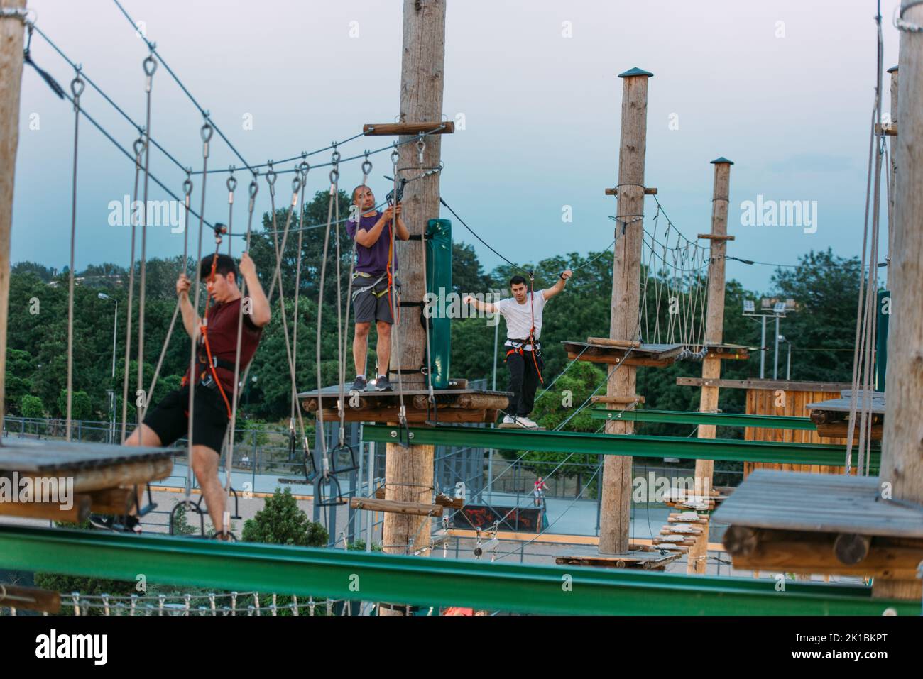 Three adventure men one standing the other going on the wire and the ...