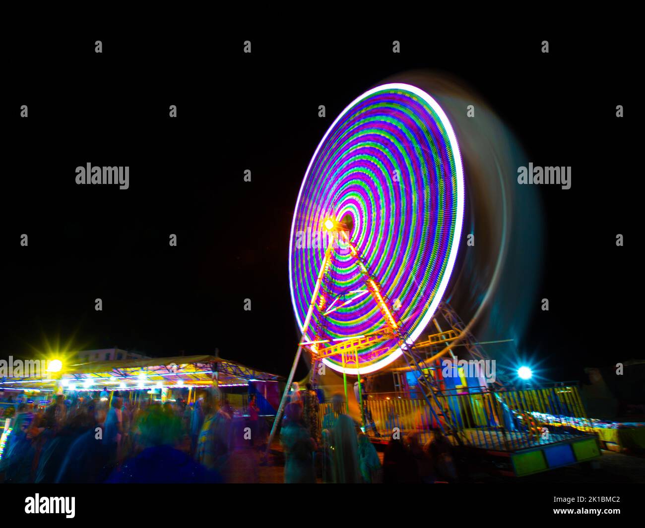 Moving light from ferris wheel at night Stock Photo - Alamy