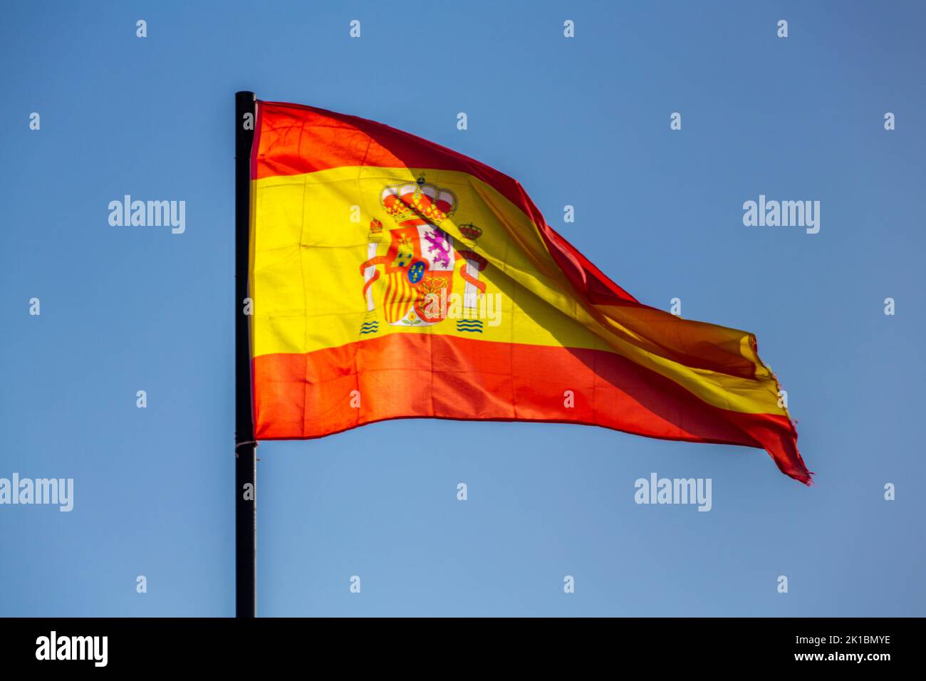 The national flag of Spain waving in a blue sky Stock Photo