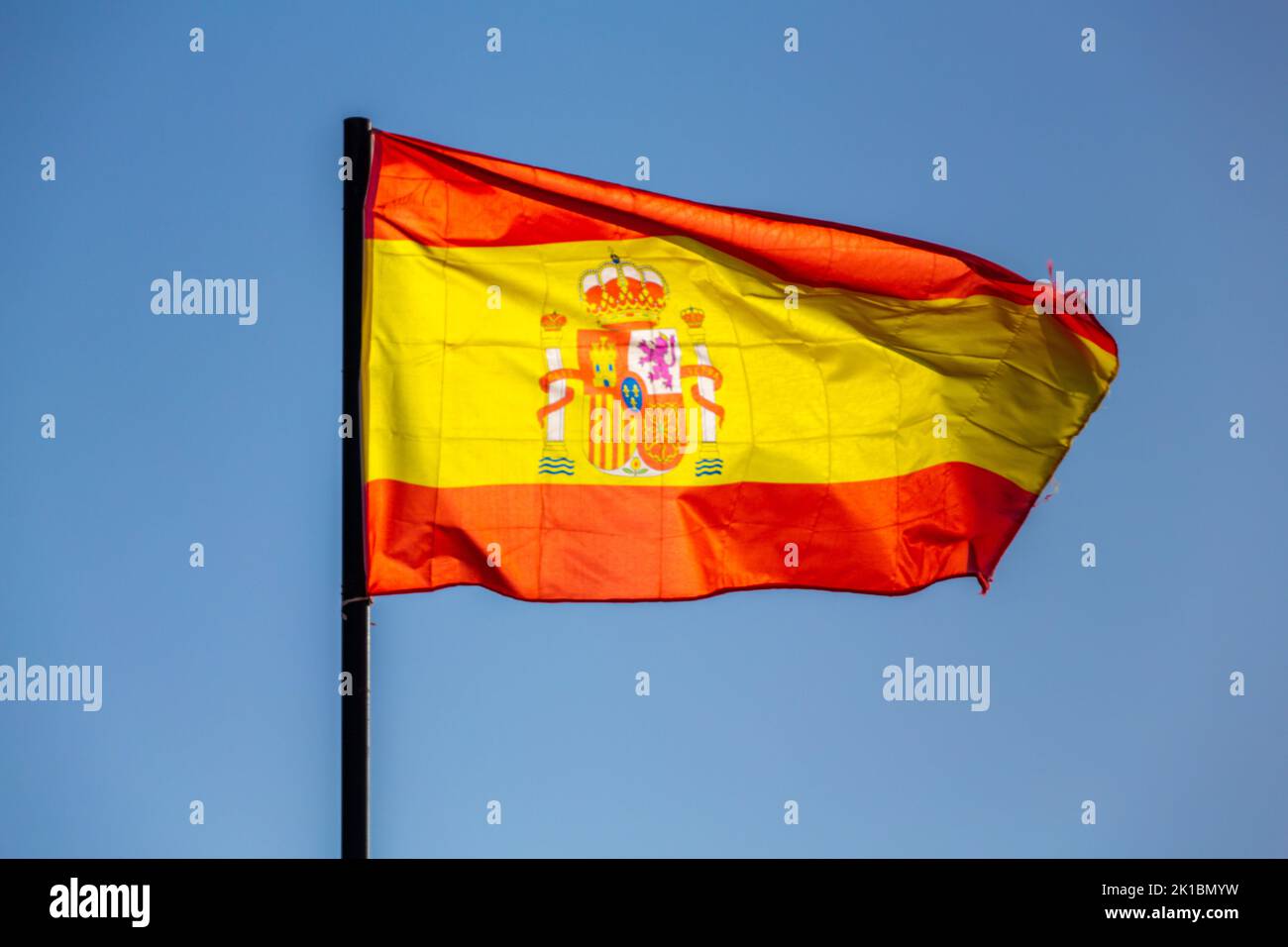 The national flag of Spain waving in a blue sky Stock Photo