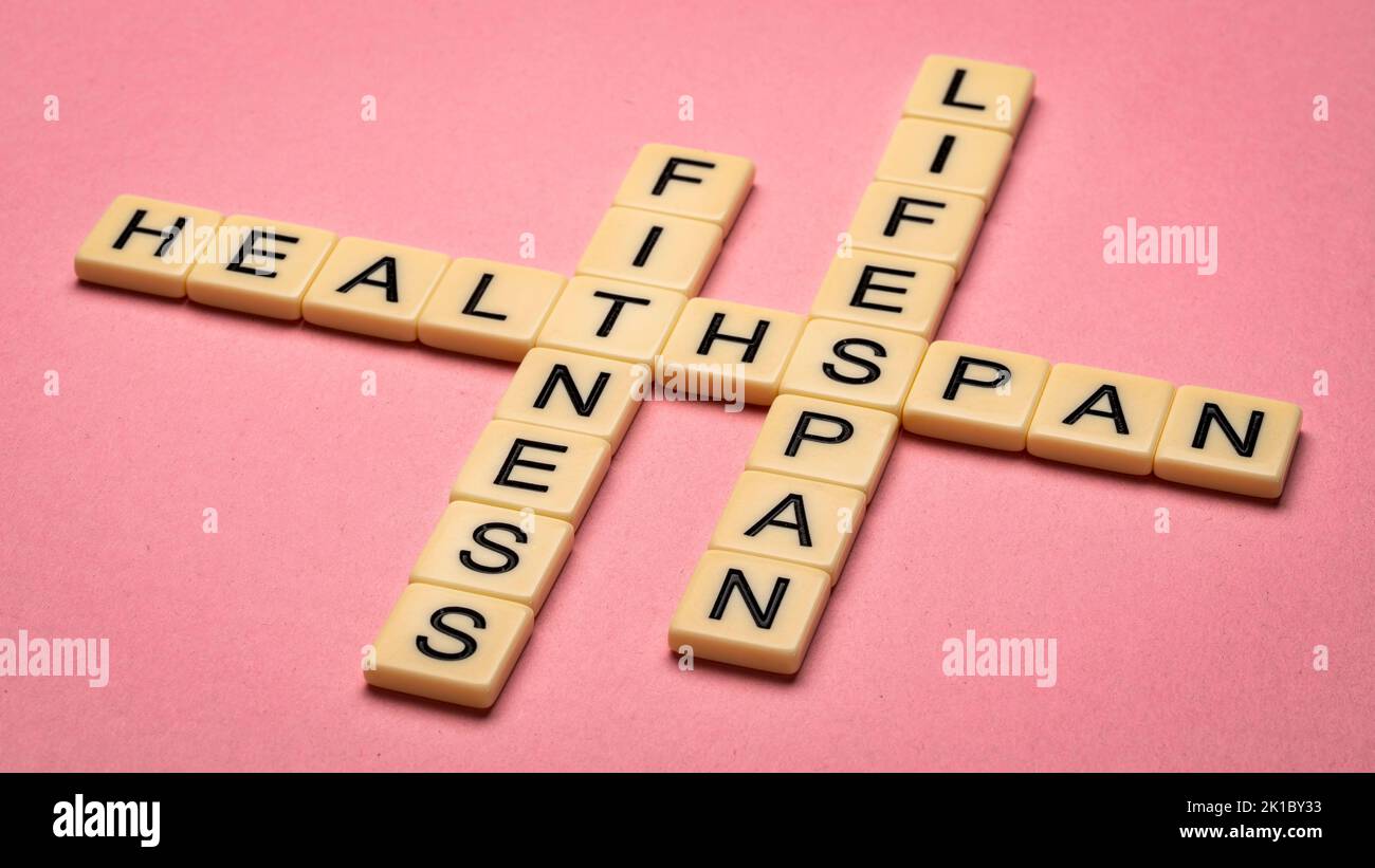 fitness, lifespan and healthspan crossword in ivory letter tiles against textured handmade paper, age and longevity concept Stock Photo