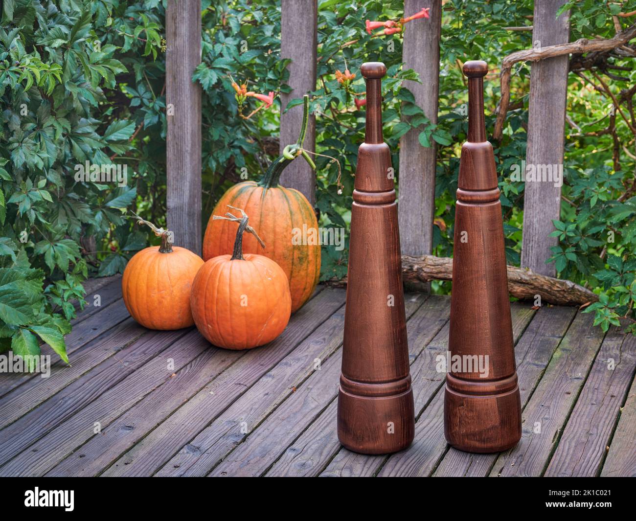 Heavy wooden Persian meels on a backyard deck with pumpkin, functional fitness concept Stock Photo