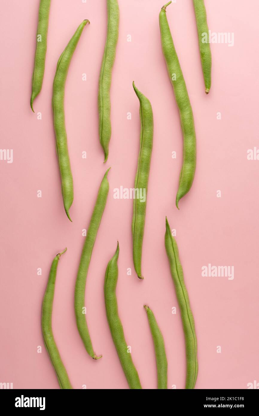 green beans on light pink background, also known as french beans, string beans or snaps, vegetable pattern Stock Photo