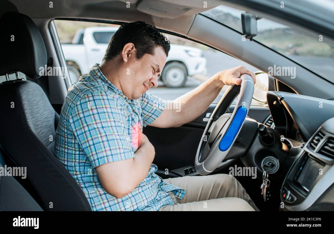 Person with heart attack while driving. Driver with chest pain. Driver's Heart Attack Concept, Suffering driver with chest pain, Male driver with Stock Photo