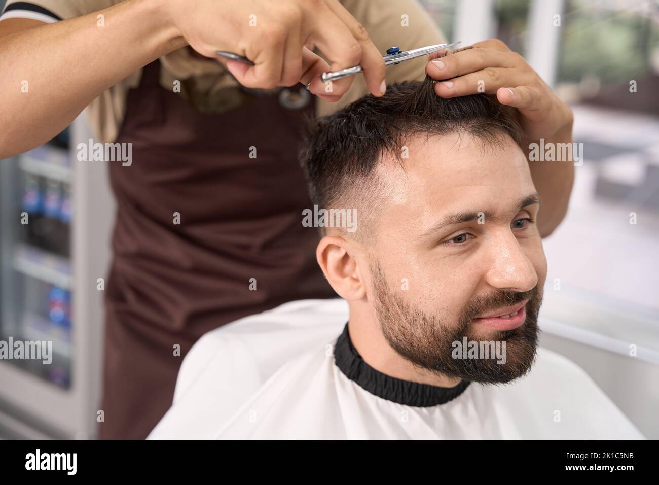 Pleasant guy having a fresh haircut at modern hair salon Stock Photo