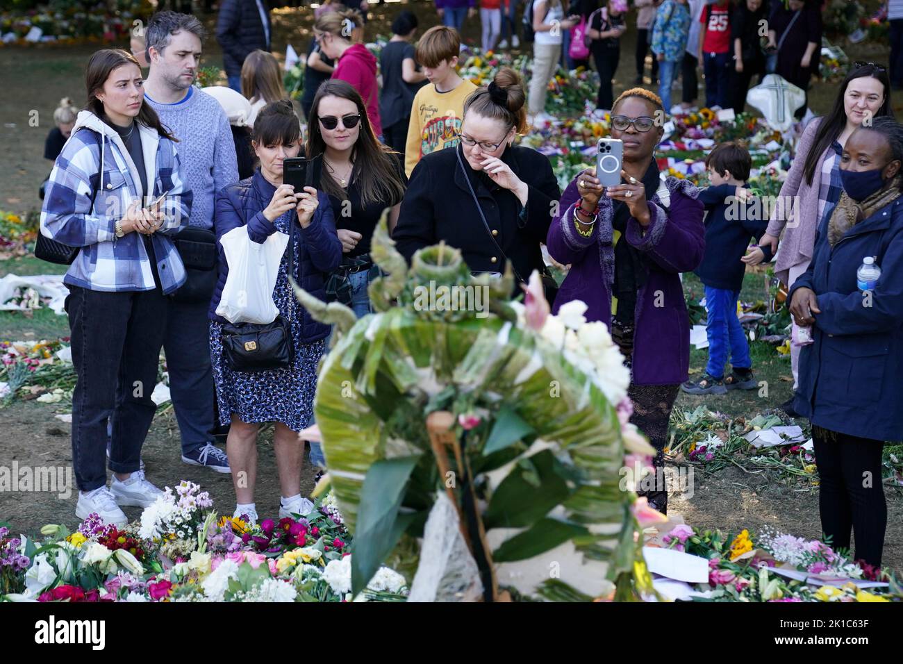 Members of the public view flowers and tributes to Queen Elizabeth II in Green Park in London, ahead of her funeral on Monday. Picture date: Saturday September 17, 2022. Stock Photo
