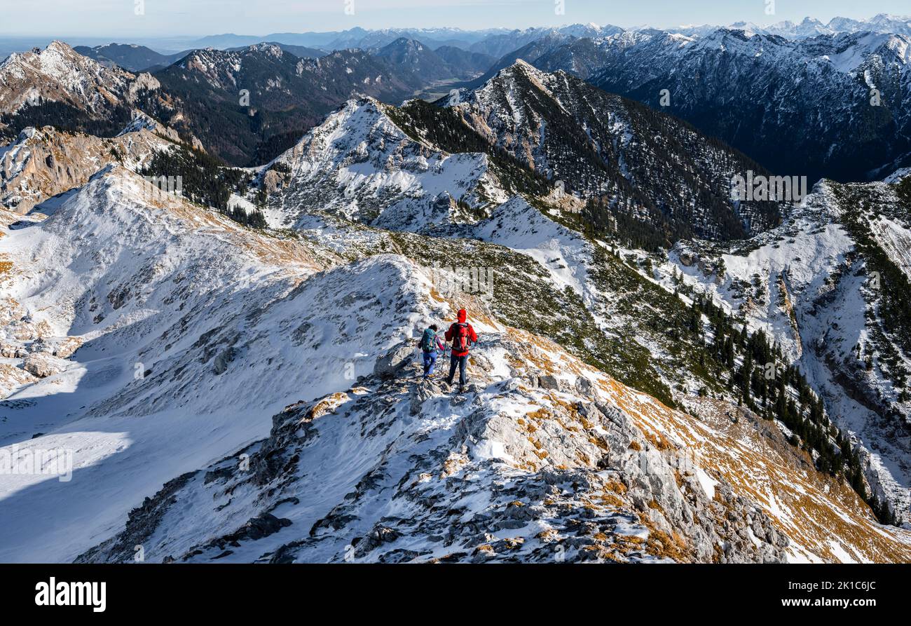 Two mountaineers on the narrow rocky snowy ridge of the Ammergauer Hochplatte, view towards Loesertaljoch, view of mountain panorama, hiking to the Stock Photo