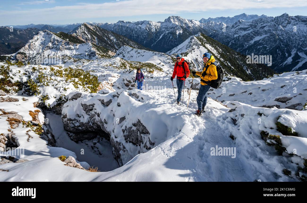 Three mountaineers between snowy karst rocks, hiking to Ammergauer Hochplatte, view of mountain panorama, hiking to Ammergauer Hochplatte, in autumn Stock Photo