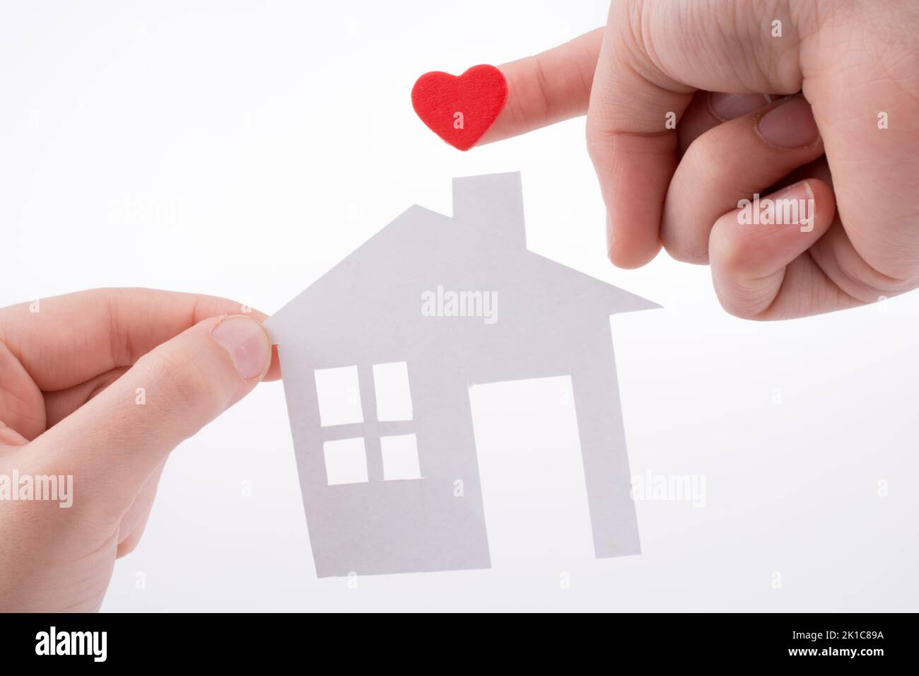 Paper house and heart shape in hand on a white background Stock Photo ...