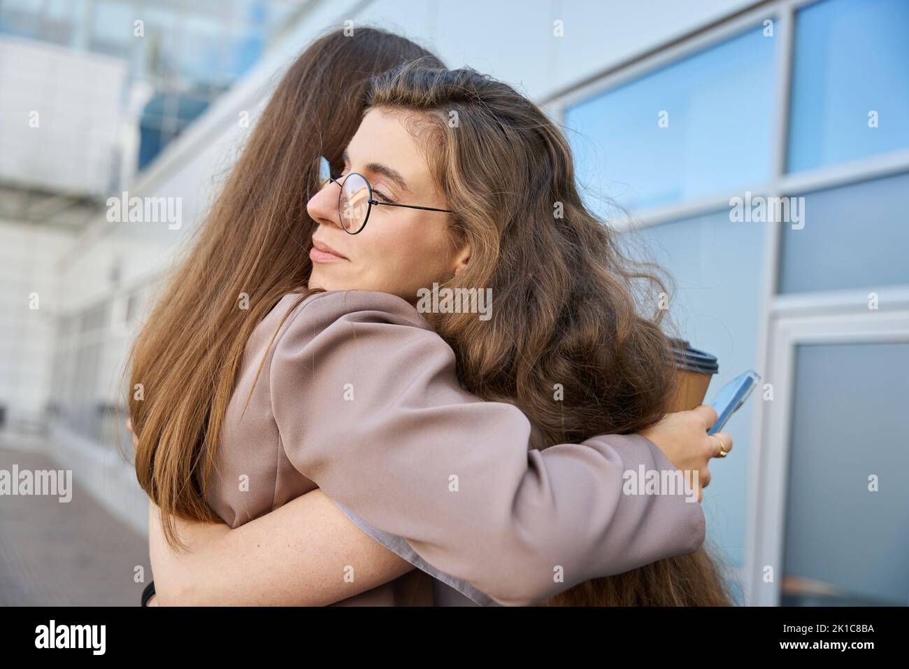 Two young women is hugging each other on the street Stock Photo