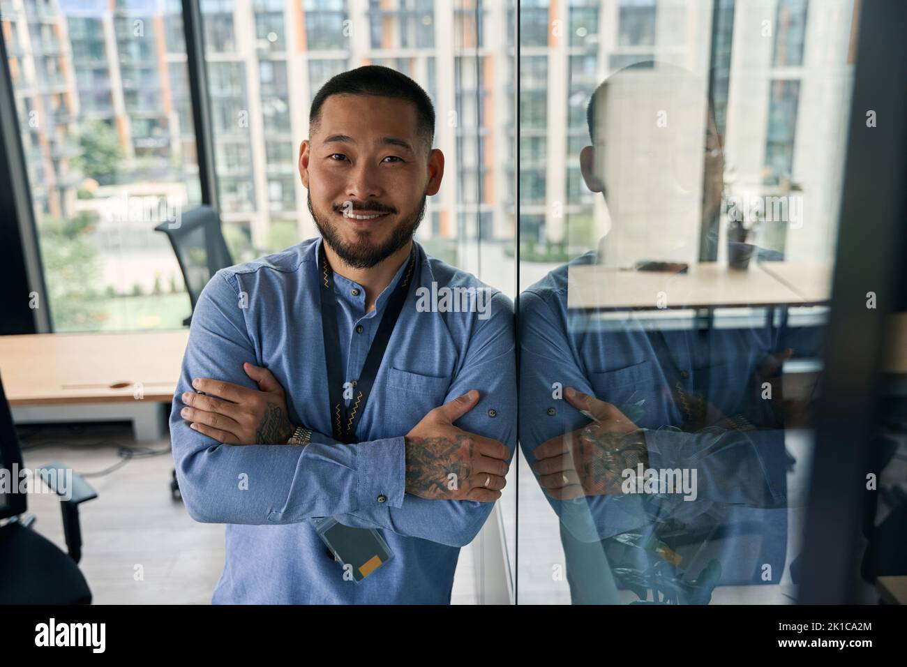 Joyous confident businessman posing for camera in workplace Stock Photo
