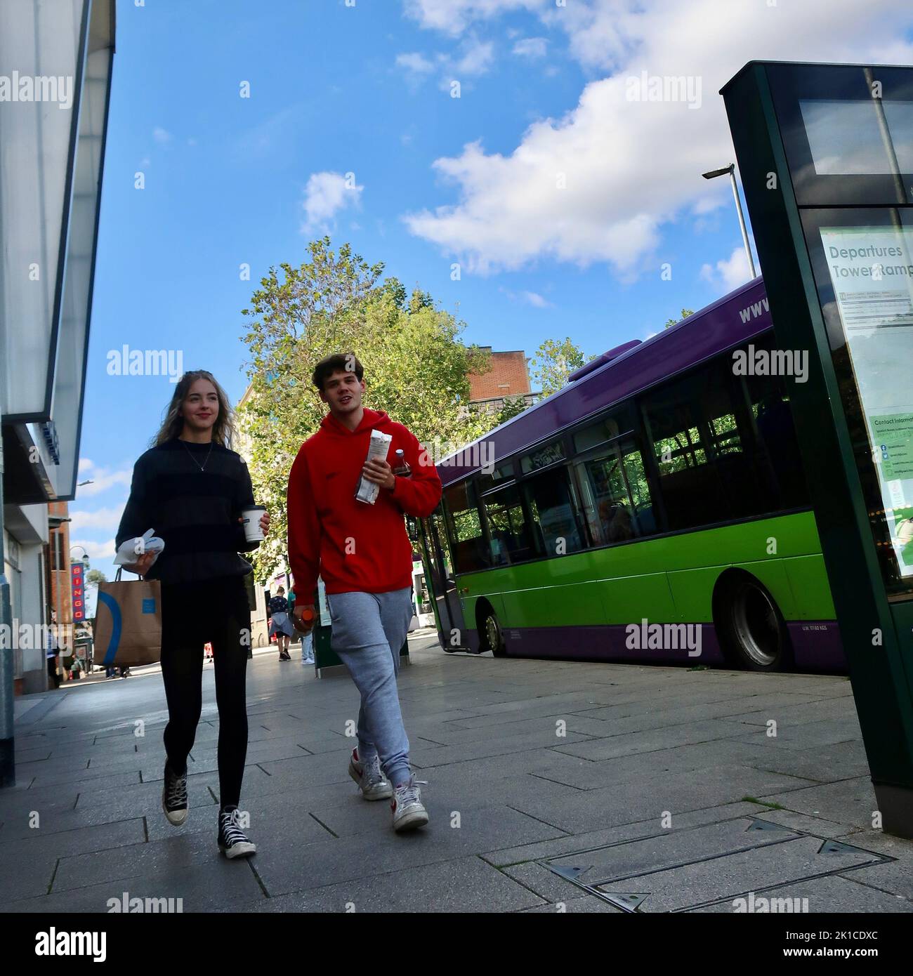 Ipswich, Suffolk, UK - 17 September 2022 : A young man and woman with food and drink walking through Tower Ramparts bus station. Stock Photo