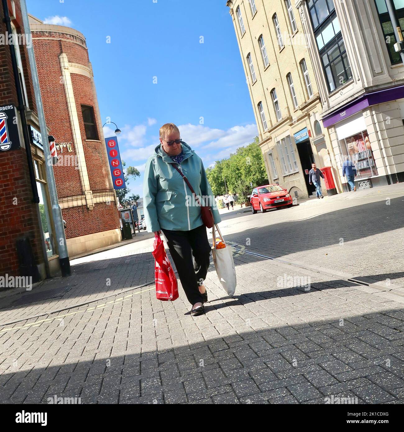 Ipswich, Suffolk, UK - 17 September 2022 : Middle aged lady walking with shopping bags towards the Tower Ramparts bus stops. Saturday afternoon. The Bingo hall is behind her. Stock Photo