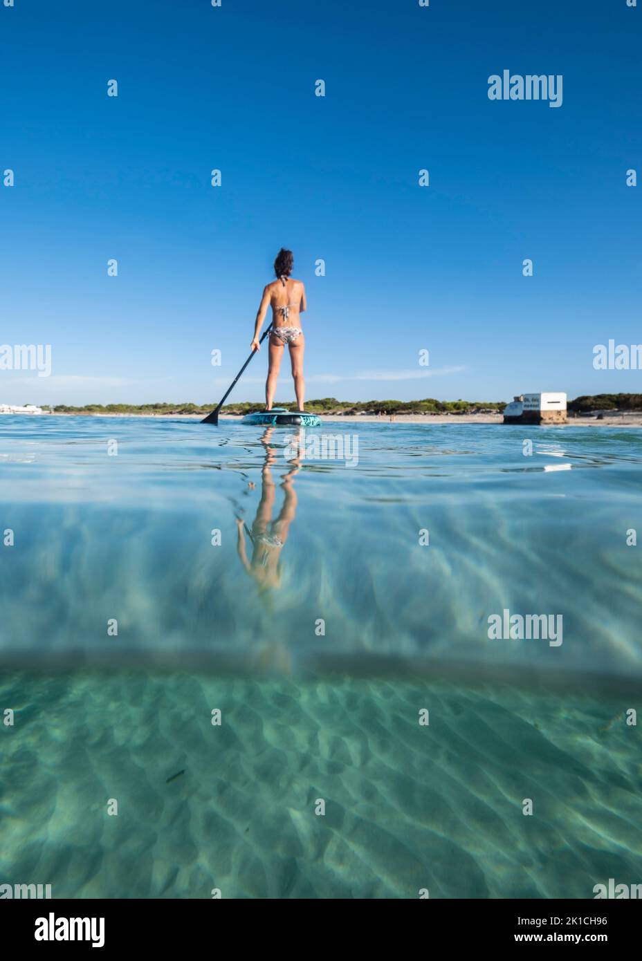 middle-aged woman practicing paddle surfing , Ses Covetes beach, Majorca, Balearic Islands, Spain Stock Photo