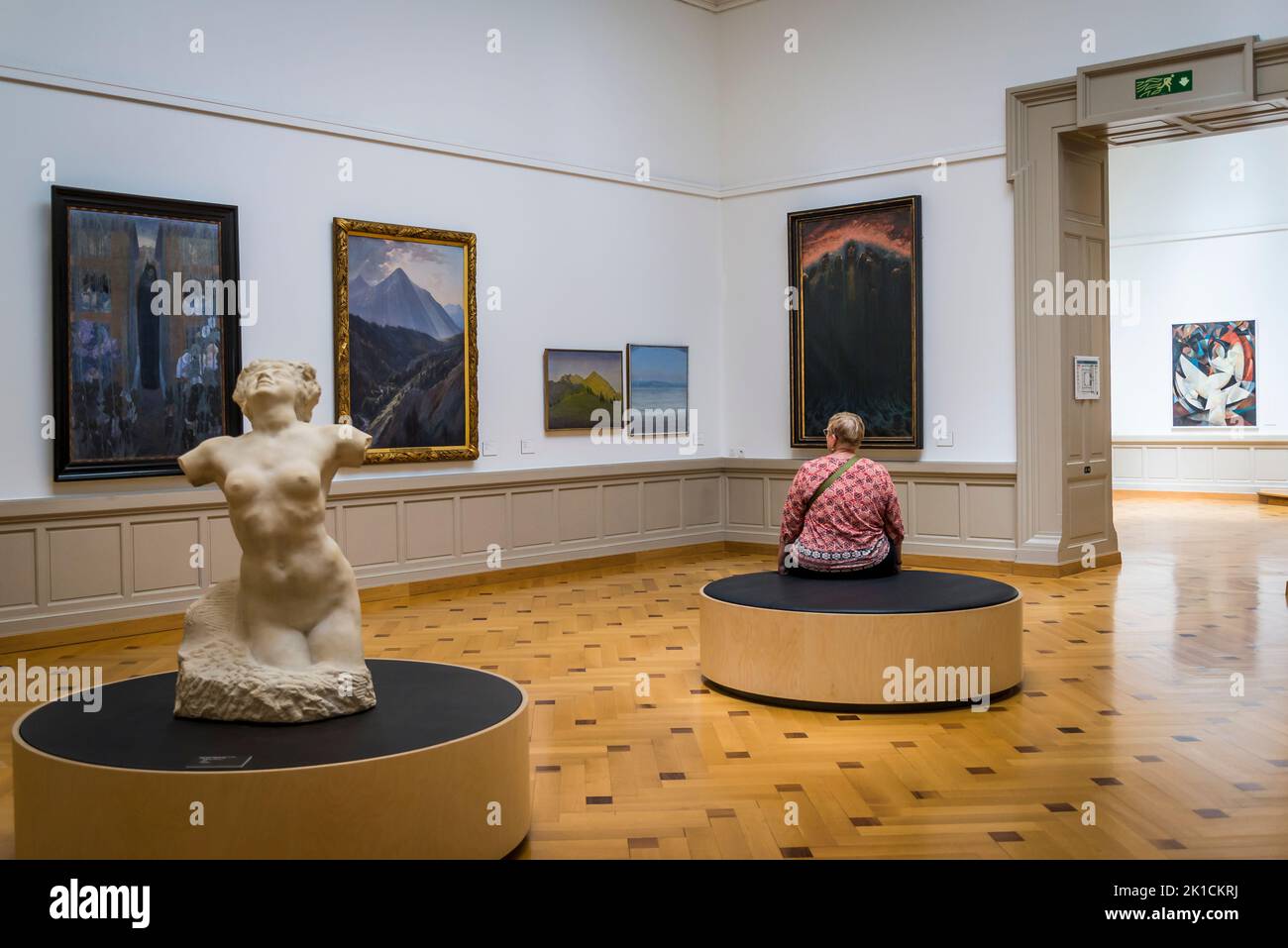 Woman sitting in a gallery with symbolist paintings, Art and history museum, the largest museum in the city, Geneva, Switzerland Stock Photo
