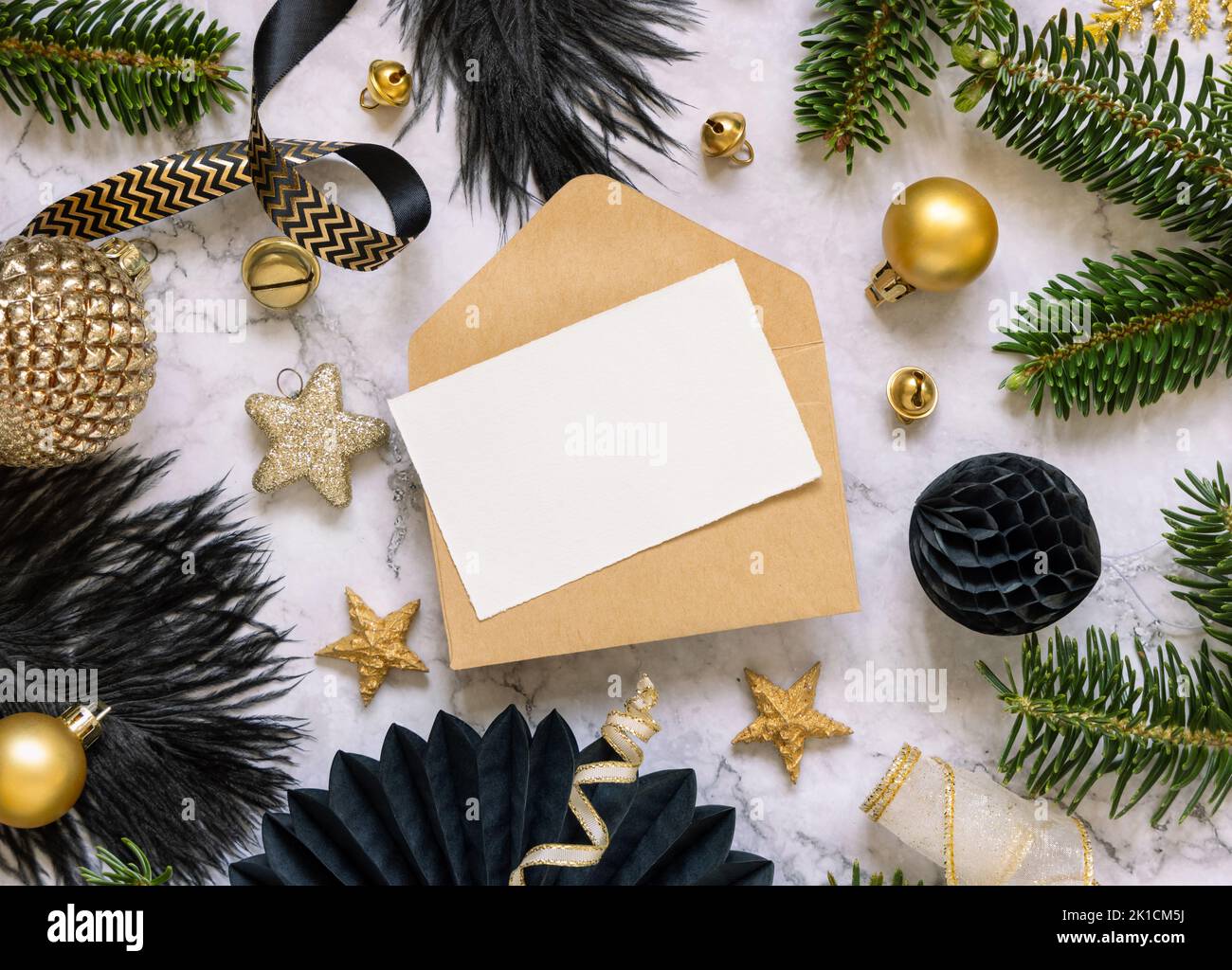 Paper card and envelope between black and golden Christmas decorations ...