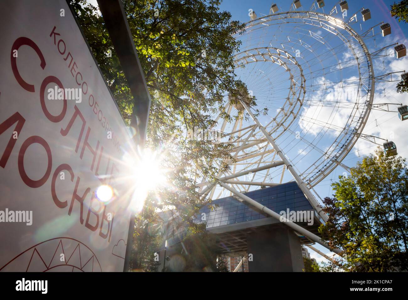 Moscow, Russia. 17th of September, 2022. View of the Sun of Moscow Ferris wheel at the VDNKh exhibition centre and park. Being 140 metres high, it is the largest observation wheel in Europe with 30 sealed capsules. The banner reads 'the Sun of Moscow' Stock Photo