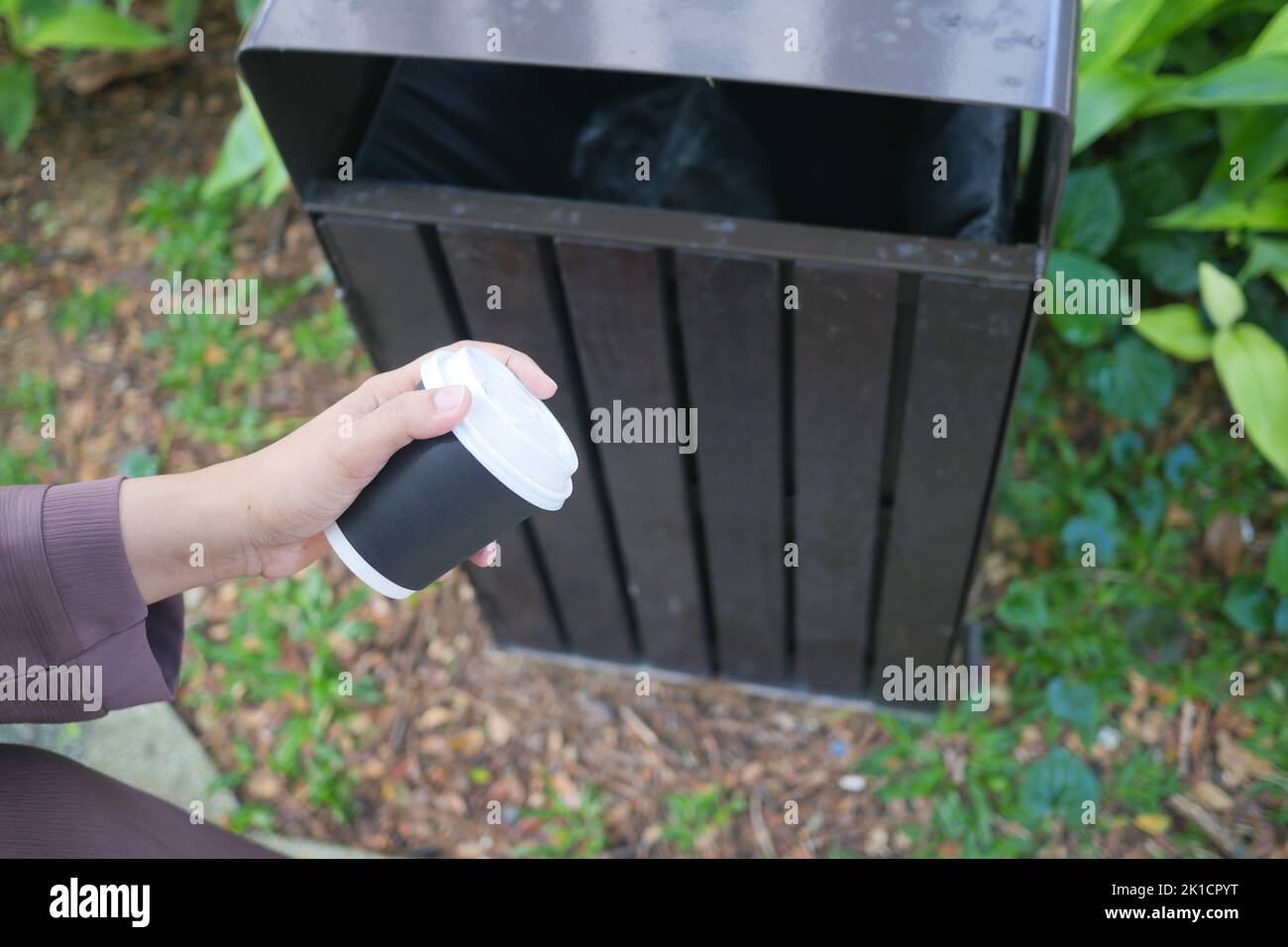 women hand throwing an empty coffee paper cup in the garbage trash or bin Stock Photo Alamy