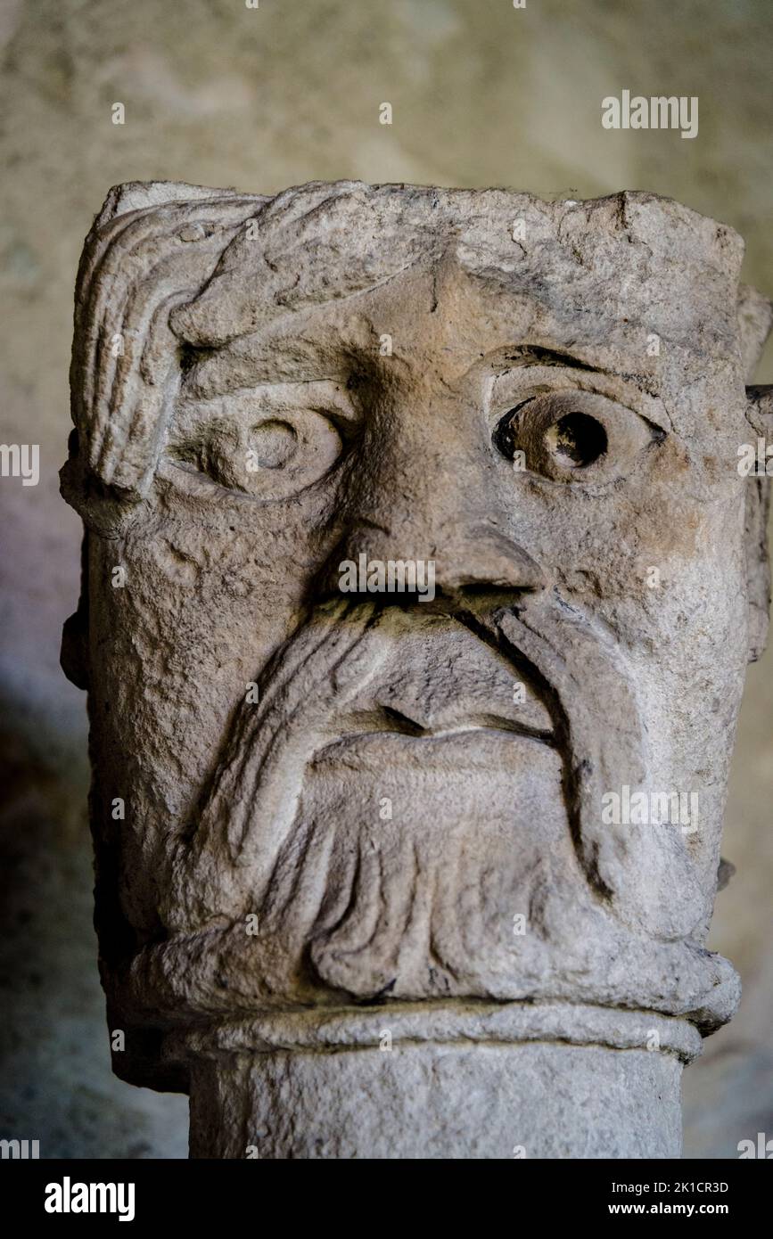 Medieval sculture placed on top of the column or capital in a Romanesque church Cloister, Vienne, France Stock Photo