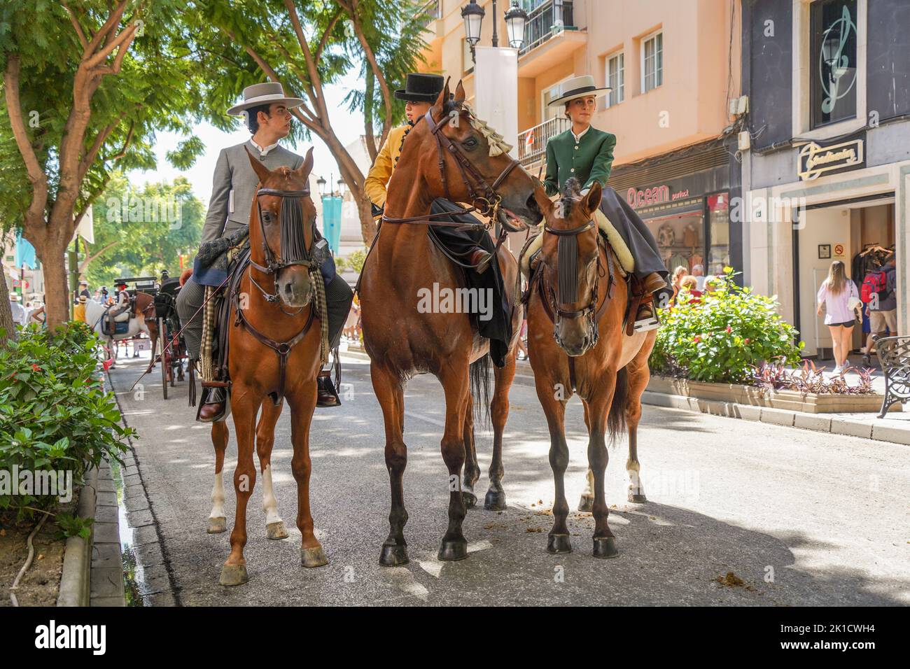 Men and women in traditional spanish costumes horseback riding during