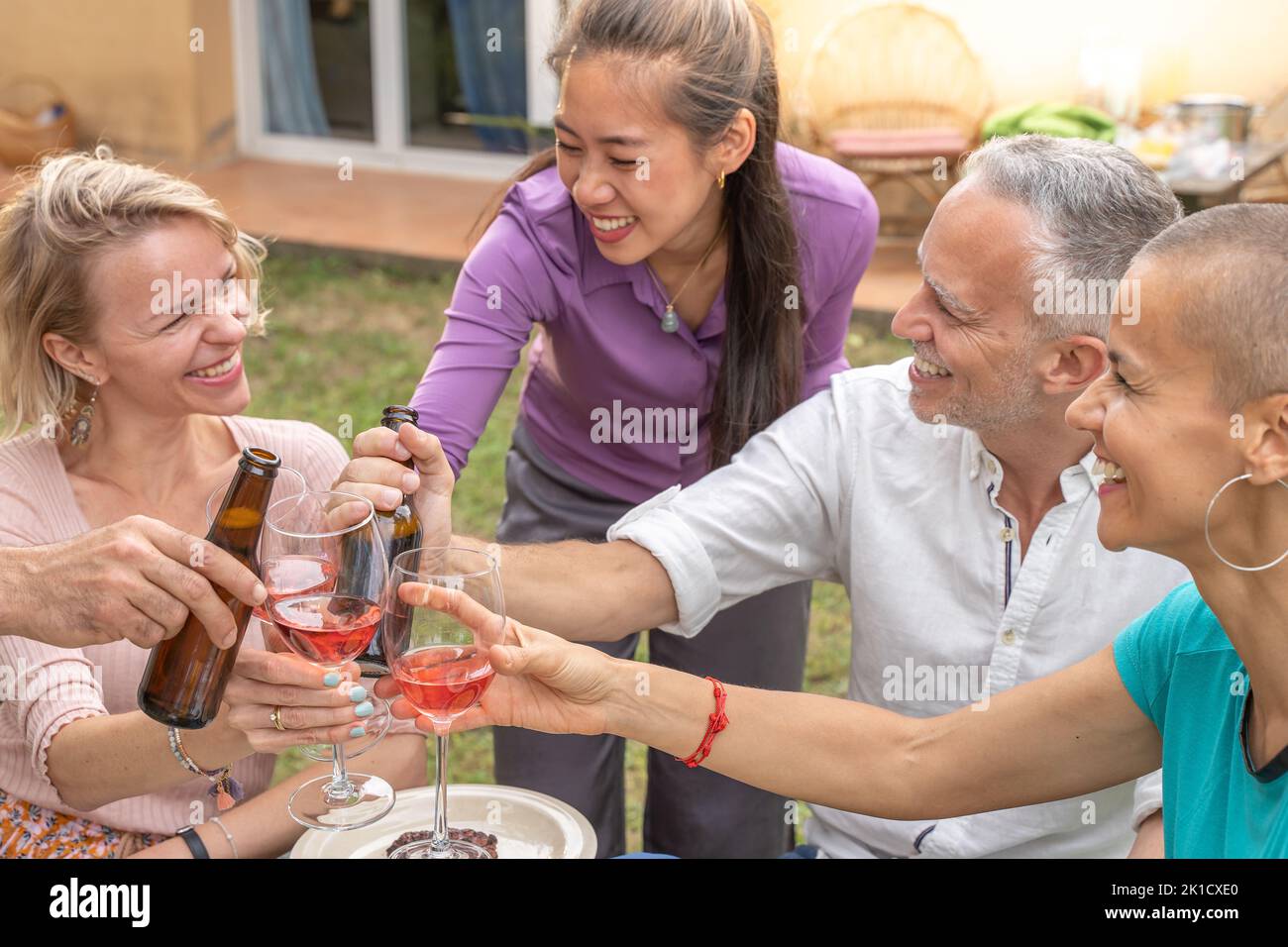 Diverse group toasting around table hi-res stock photography and images ...