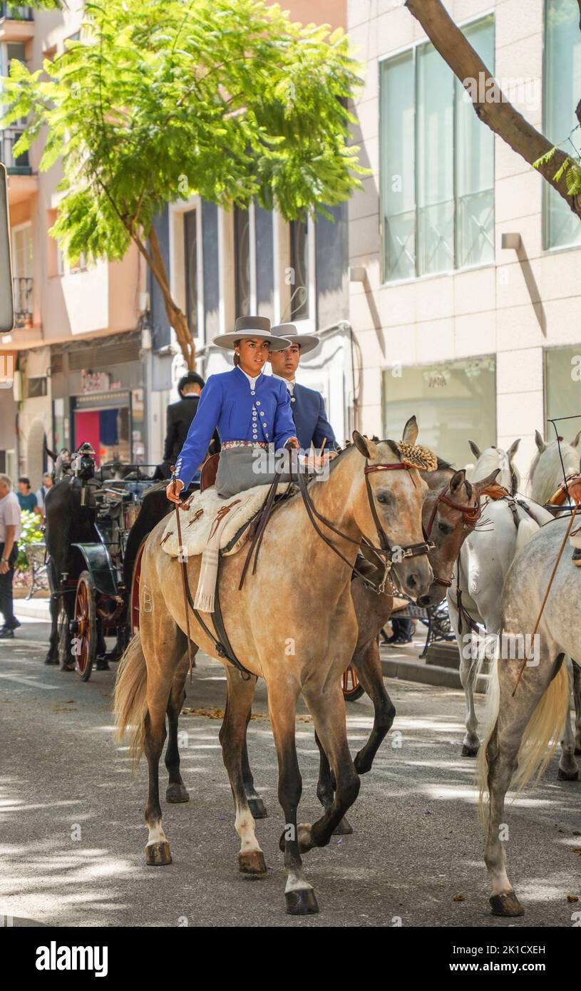 Men and women in traditional spanish costumes horseback riding during annual Horse day. Fuengirola, Andalusia, Costa del Sol, Spain. Stock Photo