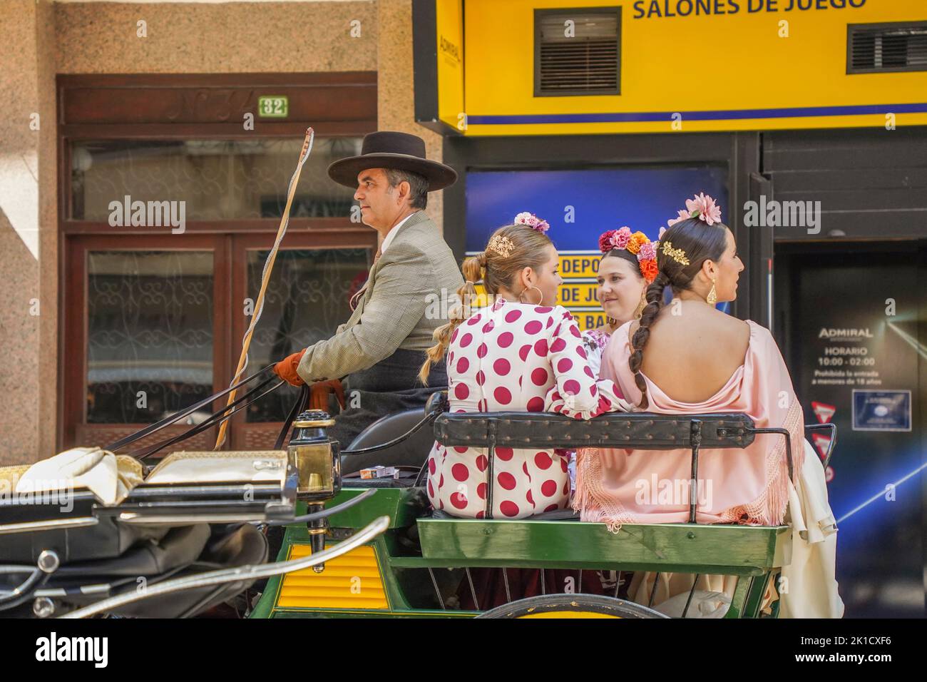 Spanish men and woman in traditional decorated horse carriage, during annual Horse day. Fuengirola, Andalusia, Costa del Sol, Spain. Stock Photo