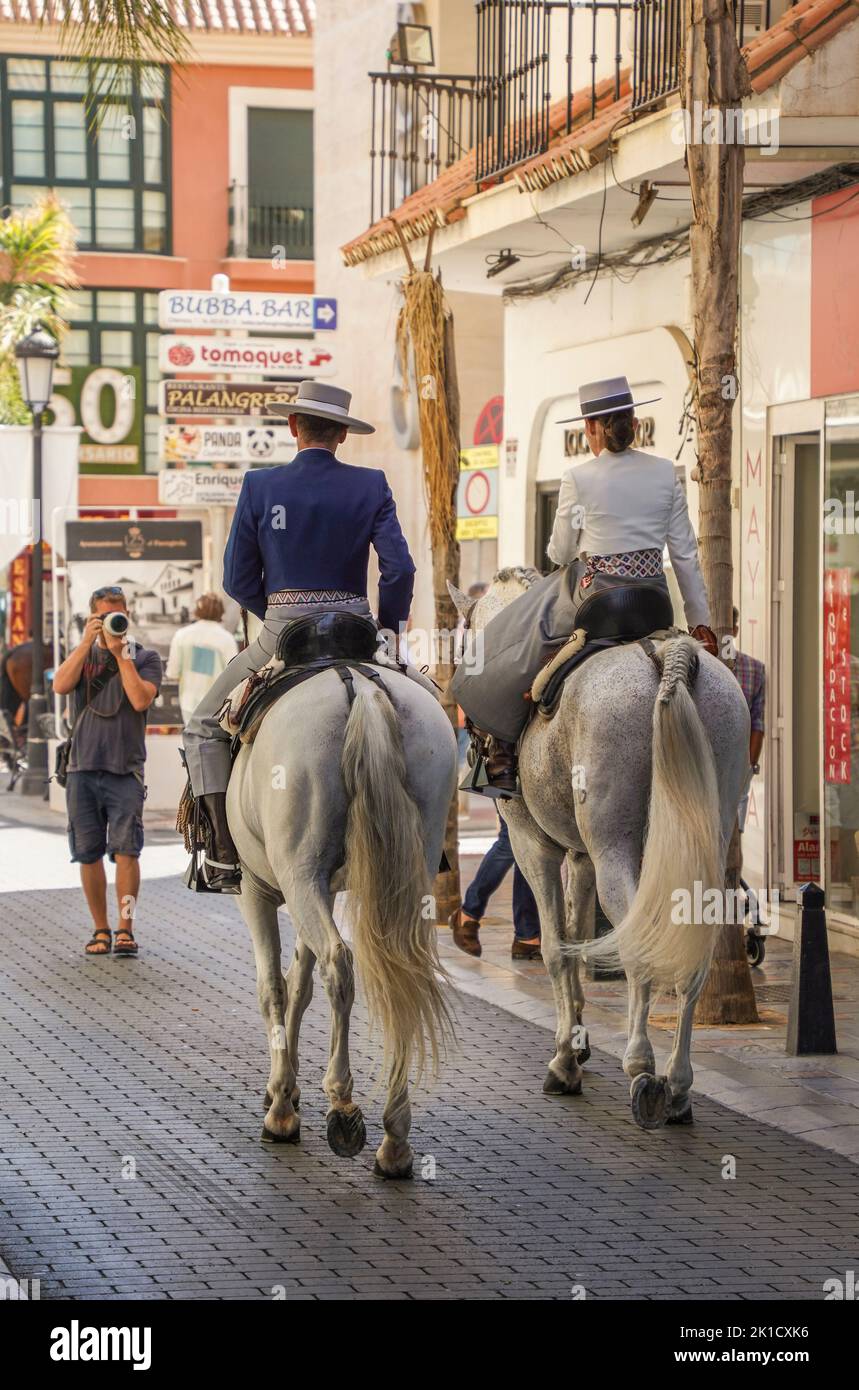 Man and woman in traditional spanish costumes horseback riding during annual Horse day. Fuengirola, Andalusia, Costa del Sol, Spain. Stock Photo