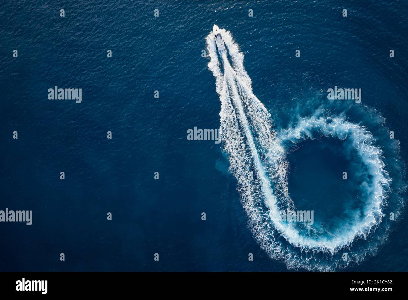 Aerial top view of a motor powerboat forming a circle of waves Stock Photo