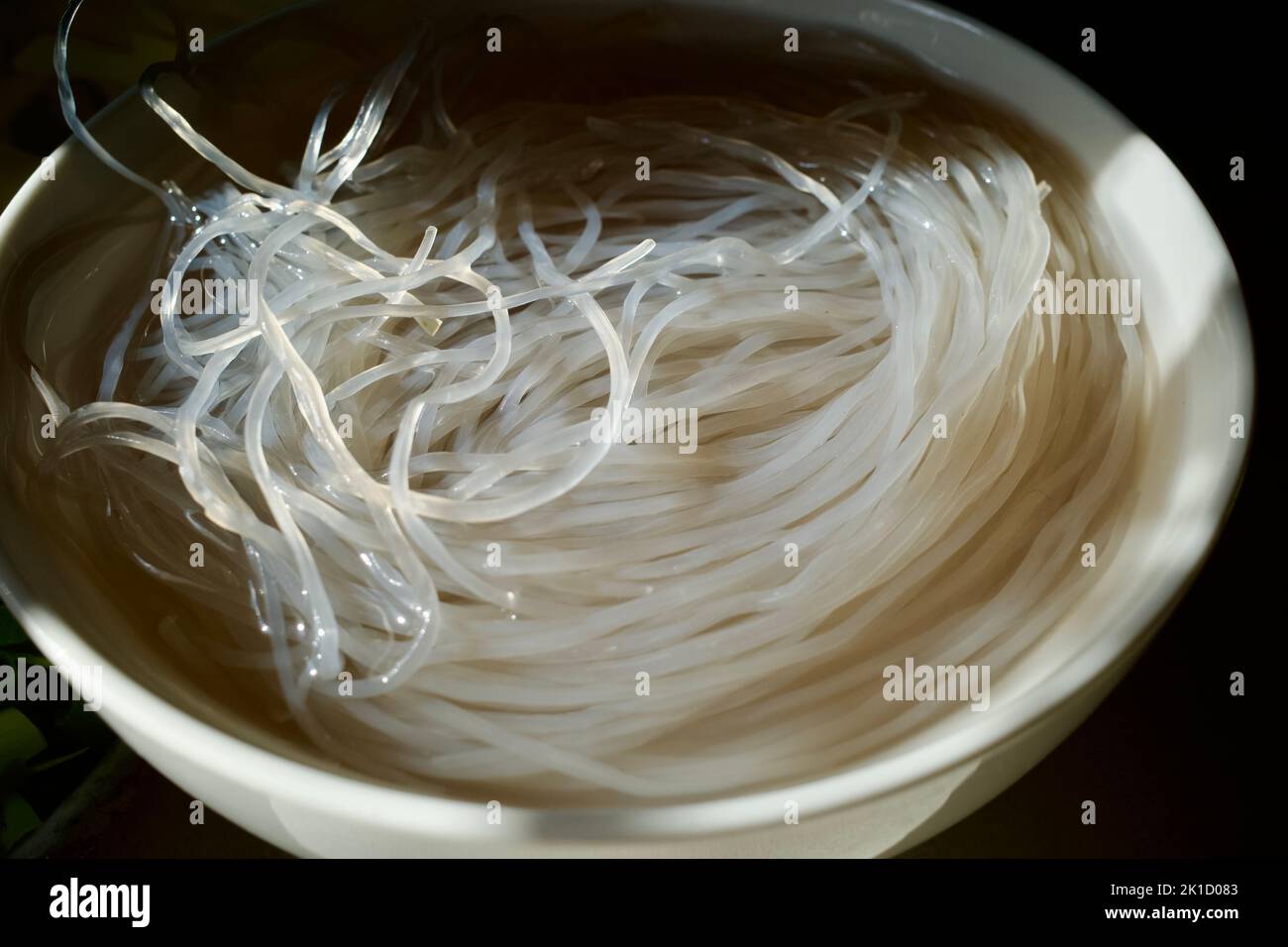 Uncooked glass noodles soaked in water. The photo was taken under natural light on a kitchen worktop Stock Photo
