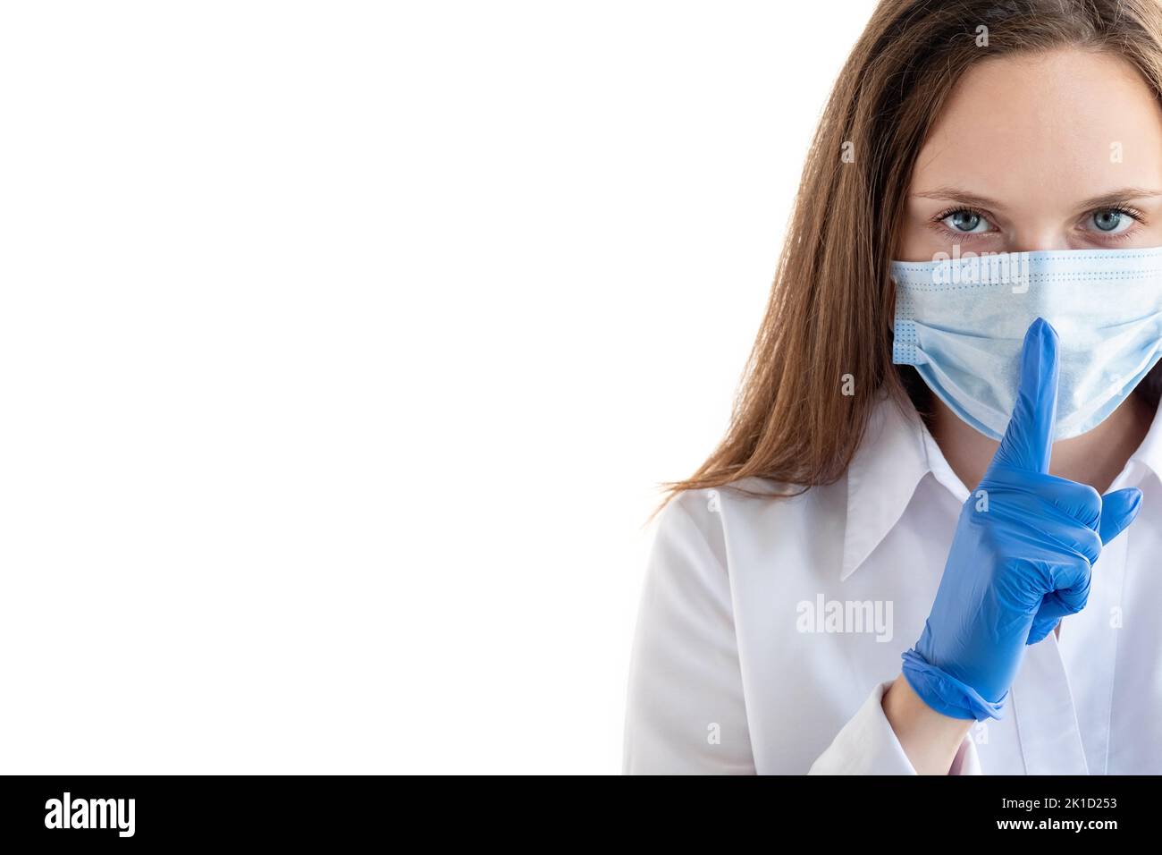 Covid-19 prevention. Silence gesture. Business woman. Confident lady in protective mask gloves pitting finger on mouth looking at camera isolated whit Stock Photo