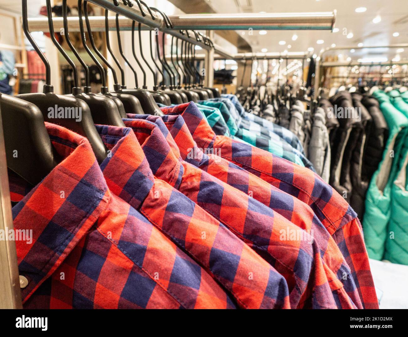 Shirts on hangers in clothing store. Stock Photo