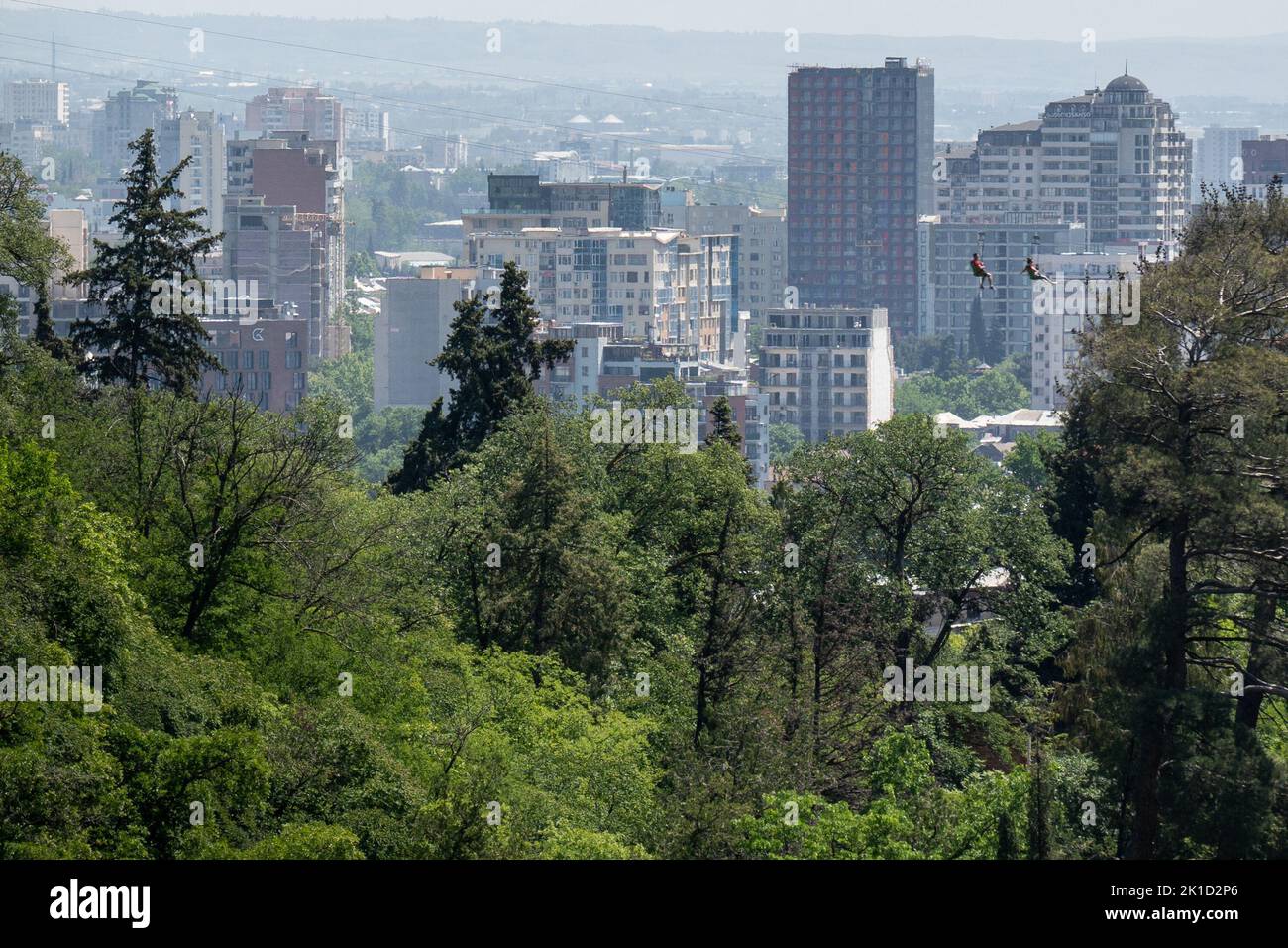 The zip-lining in the green park against the Tbilisi skyline. Georgia. Stock Photo