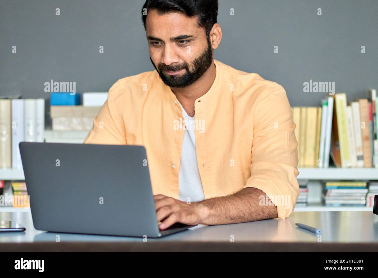 Indian business man entrepreneur using laptop computer in office online working. Stock Photo