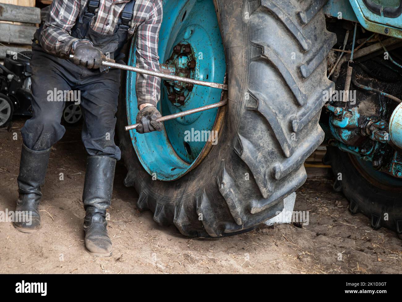 Change agricultural tractor broken tube tire at home. Man worker use