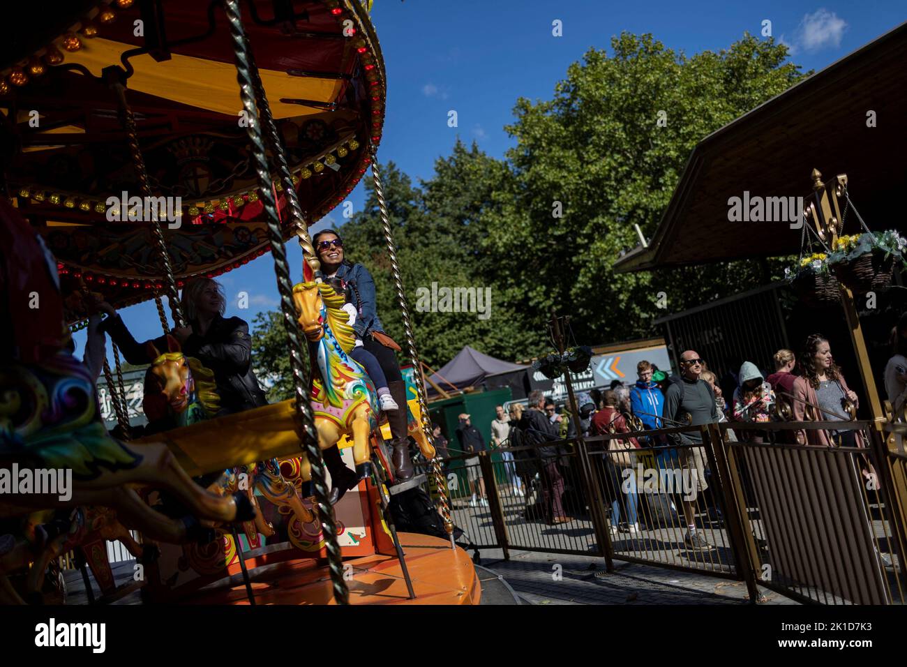 A woman is seen at a carousel as people stand in a queue to pay respect to Britain's Queen Elizabeth, following her death, in London, Britain September 17, 2022. REUTERS/Carlos Barria Stock Photo