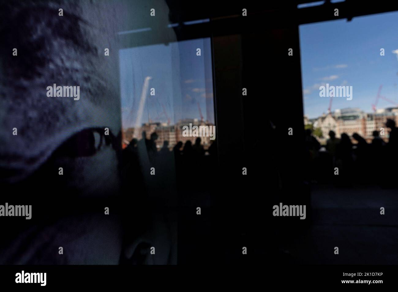 The eyes of Britain's Queen Elizabeth are seen projected on a screen as people stand in a queue to pay respect to Queen Elizabeth, following her death, in London, Britain September 17, 2022. REUTERS/Carlos Barria Stock Photo